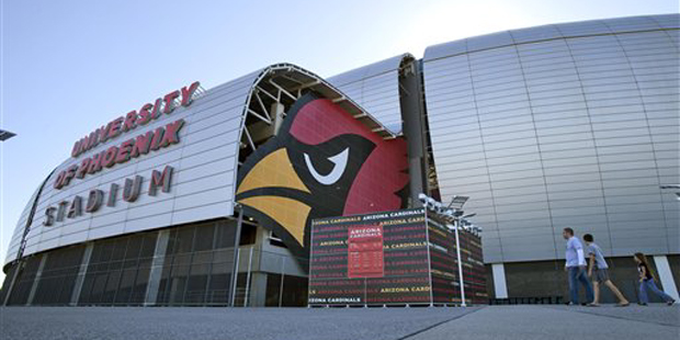 Pedestrians walk outside of the University of Phoenix Stadium, Tuesday, Oct. 11, 2011, in Glendale,...