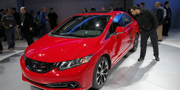 Show attendees look at the new Honda Civic at the LA Auto Show in Los Angeles, Thursday, Nov. 29, 2...