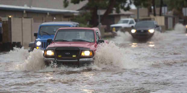 Vehicles drive through the flood prone area of 39th Avenue between Peoria Avenue and Cactus Road du...