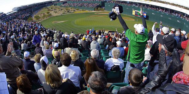 Fans cheer on the 16th green during the first round of the Phoenix Open PGA golf tournament Friday,...