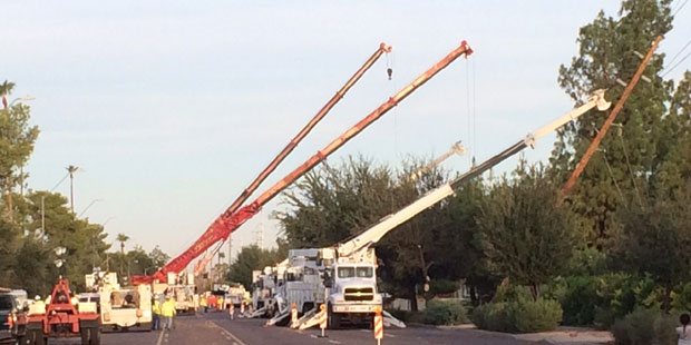 A crew takes care of  a downed power pole.  (KTAR Photo/Jim Cross)...