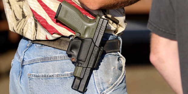 Michael Johnson wears a firearm as he waits outside of Roseburg Municipal Airport for President Bar...