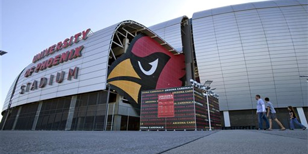 Pedestrians walk outside of the University of Phoenix Stadium, Tuesday, Oct. 11, 2011, in Glendale,...