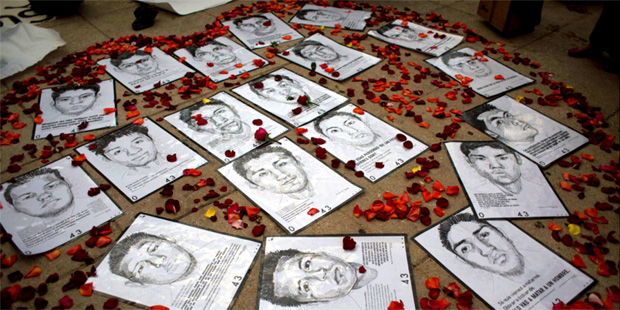 In this March 26, 2015 file photo, drawings of some of 43 missing rural college students are surrou...