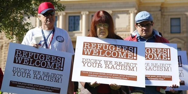 Supporters for the welcoming of Syrian refugees pause during a rally at the Arizona Capitol Tuesday...