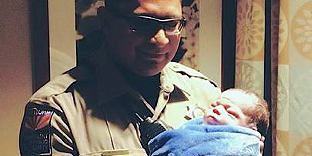 Trooper Miguel Rincon and the child he helped to deliver. (Facebook Photo)...