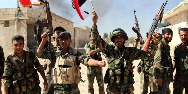In this file photo taken on Sunday, Oct. 11, 2015, Syrian soldiers waving Syrian flags celebrate th...