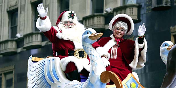 A couple dressed as Santa Claus and Mrs. Claus wave to spectators during the 96rd annual Thanksgivi...