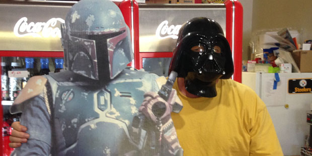 Cardboard cutout of Boba Fett with Randy Walters, owner of Wimpys Paradise, wearing a Darth Vader m...