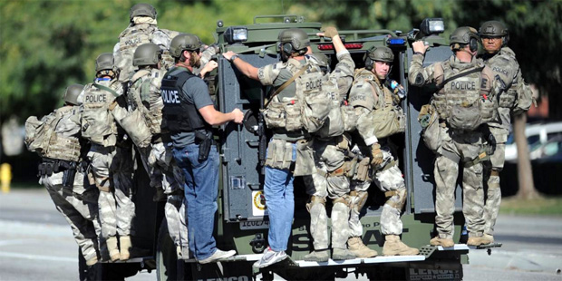 A SWAT vehicle carries police officers near the scene of a shooting in San Bernardino, Calif. on We...