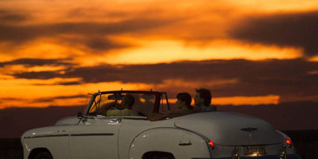 In this Sept. 30, 2015 file photo, tourists ride a vintage American convertible during sunset on th...