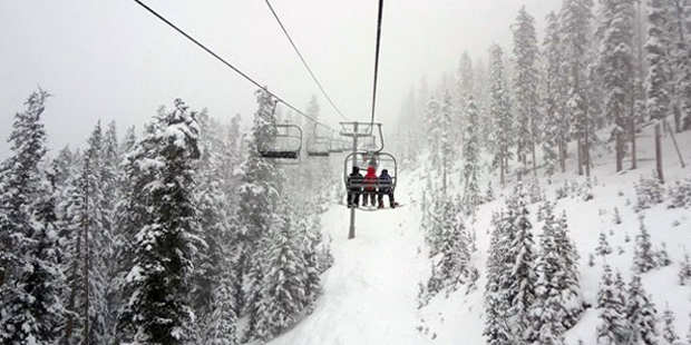 Skiers ride a ski lift at Arizona Snowbowl, near Flagstaff, during a winter storm. (Arizona Snowbow...
