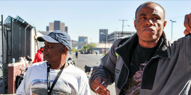Myron Fields, right, and Ephriam Martin smoke outside the Andre House in downtown Phoenix after the...