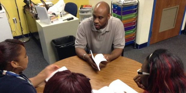 Mentor Vincent Brown talks to three girls at Lighthouse College Preparatory Academy about the impor...