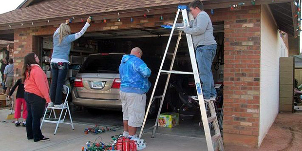 House of Heroes volunteers hang holiday lights at a veteran's home. (House of Heroes Photo)...