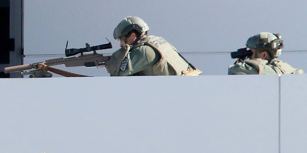 A Tucson Police sniper and a spotter watch a man in the parking lot of the Tucson Police Flowing We...