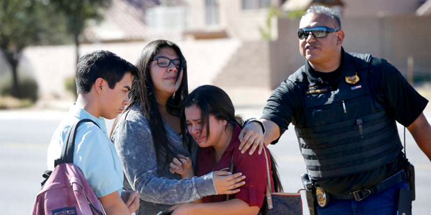Students embrace after leaving campus, Friday, Feb. 12, 2016, in Glendale, Ariz. after two teens we...