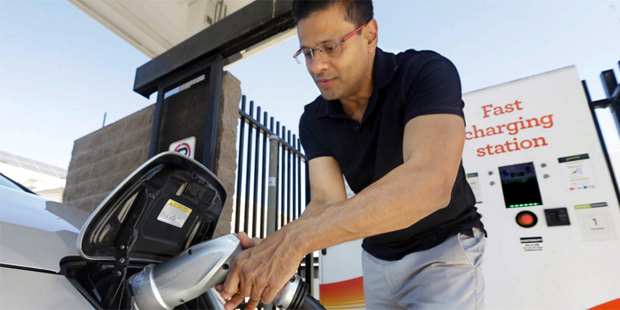 In this photo taken Thursday, Sept. 17, 2015, Darshan Brahmbhatt, plugs a charger into his electric...