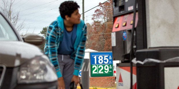 FILE - In this Wednesday, Nov. 25, 2015, file photo, Cornelio Bonilla pumps gas at Best Food Mart g...