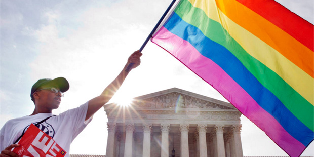 Carlos McKnight of Washington, waves a flag in support of gay marriage outside of the Supreme Court...