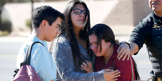 Students embrace after leaving campus, Friday, Feb. 12, 2016, in Glendale, Ariz. after two teens we...