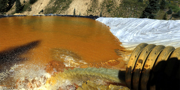 In this Aug. 14, 2015, file photo, water flows through a series of sediment retention ponds built t...