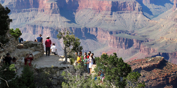 In this Wednesday, Aug. 19, 2015 photo, visitors gather at an outlook on the South Rim of Grand Can...