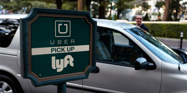 In this Jan. 14, 2016, photo, a driver waits to pick up passengers at an Uber and Lyft pick up area...