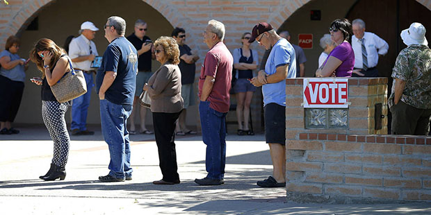 Voters wait in line to cast their ballot in Arizona's presidential primary election, Tuesday, March...