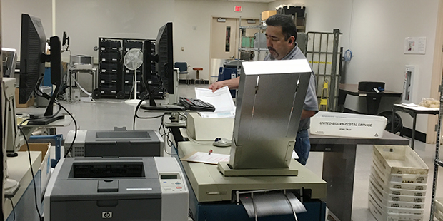 A Maricopa County worker counts early ballots Monday cast in Arizona's presidential preference elec...