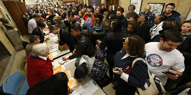 Voters crowd into foyer of Smiley Middle School to check in with their precinct captains to attend ...