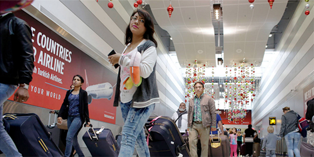 Travelers walk through Miami International Airport Wednesday, Nov. 25, 2015, in Miami. The big Than...
