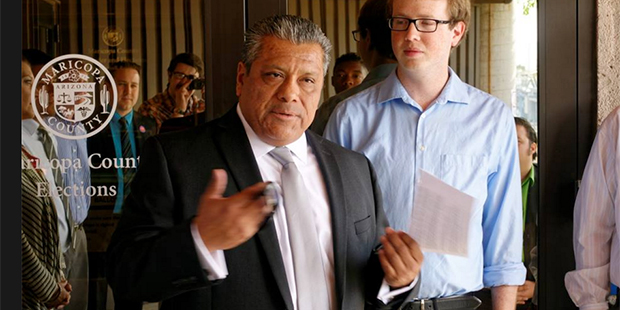 Joe Rodriguez, left, speaks with reporters and supporters in front of the Maricopa County Elections...