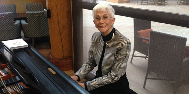 Pat Uline, 90, sits down at her piano at Sagewood, her senior living community. (KTAR Photo/Mike Sa...