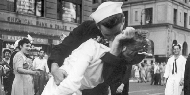 In this Aug. 14, 1945, picture, a sailor and a nurse kiss while Gloria Bullard watches at far left,...