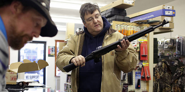Joe McGrew, of Lake Ariel, Pa., inspects his new Saiga AK-47 style rifle as Rich Johnson, left, own...