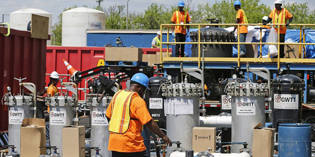 Workers operate treatment equipment to clean wastewater from coal ash at a treatment facility outsi...