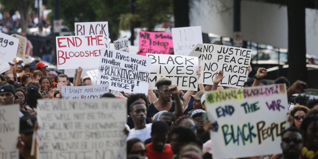 Demonstrators march through downtown Atlanta to protest the shootings of two black men by police of...