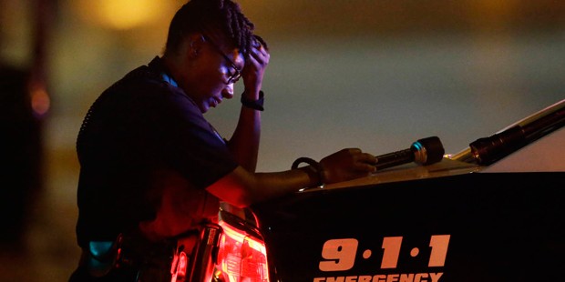 A Dallas police officer, who did not want to be identified, takes a moment as she guards an interse...