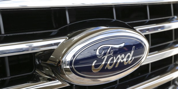 This Thursday, Nov. 19, 2015, photo, shows the Ford blue oval badge in the grill of a vehicle on di...