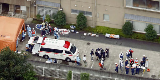 Ambulance crew and police officers  are seen outside a facility for the handicapped where a number ...