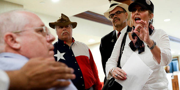 Lori Hack tries to pick up her delegate credential for the Republican National Convention on Monday...