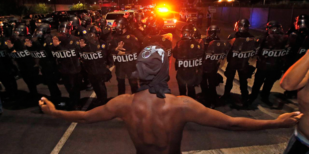 A protester raises him arms in front of a police blockade as marchers take to the streets to demons...