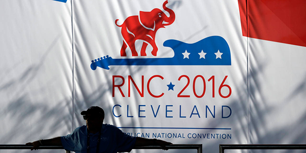 A man sits outside Quicken Loans Arena before the start of the third day session of the Republican National Convention in Cleveland, Wednesday, July 20, 2016. (AP Photo/John Locher)