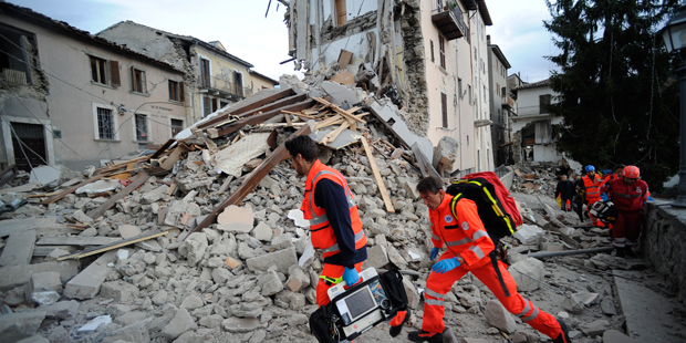 Rescuers search a crumbled building in Arcuata del Tronto, central Italy, where a 6.1 earthquake st...