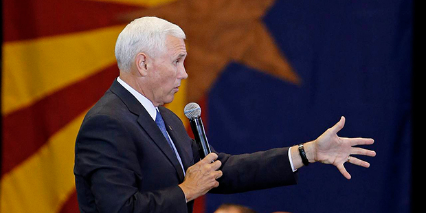 With the Arizona state flag in the background, Republican vice presidential nominee Mike Pence answ...