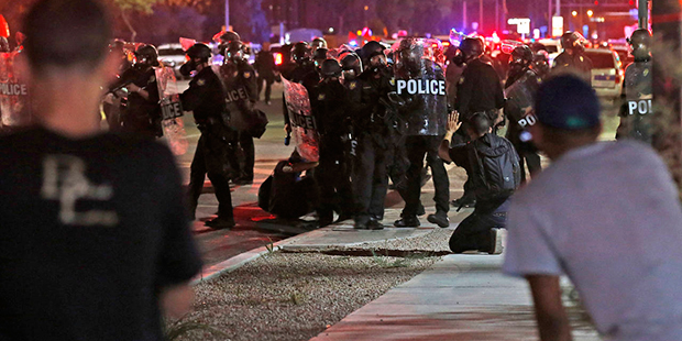 Police in riot gear move in to break up a group of marchers as hundreds take to the streets to prot...