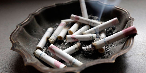 FILE - In this Saturday, March 2, 2013, photo, a cigarette burns in an ashtray at a home in Haynevi...