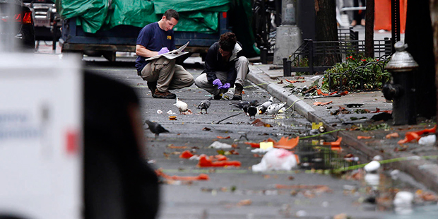 Evidence teams investigate at the scene of Saturday's explosion on West 23rd Street in Manhattan's ...