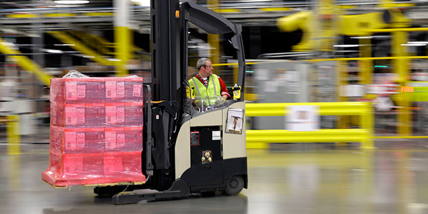 FILE - In this Feb. 13, 2015, file photo, a forklift operator moves a pallet of goods at a Amazon.c...